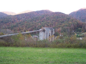 Against the colorful hills a mine tower rises some fifty feet, with a long chute to deliver the coal