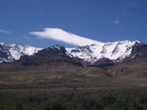 Steens mountain still snow covered with wispy clouds above