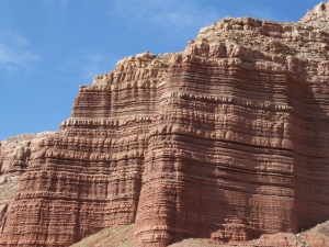A red rock outcropping with hundreds of sedimentary layers visible