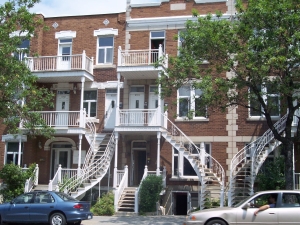 Ornate curving white iron staircases spiral up to second floor apartment doors outside Montreal