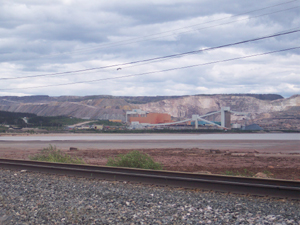 Panoramic view of a large iron mine showing parts of a mountain cut away