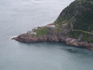 On one side of the harbor entrance sits a lighthouse with its red-roofed white buildings, and, beneath the lighthouse, the bastions of Fort Amherst, which guarded the world's most protected harbor.