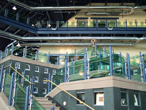 modern glass and metal with shiny open piping and a three-story atrium in the lobby of The Rooms museum.