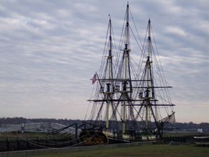 A three masted sailing ship is tied to the dock at Salem; its rigging
forming a fine tracery against the grey-blue sky.
