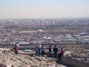 Tourists gather at a scenic overlook to see the cities on both sides of the border.
