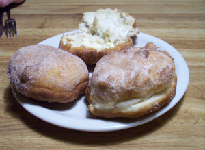 Plate with three scones, one opened and buttered
