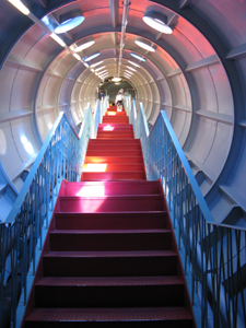 A brilliant red and blue iron staircase climbs up one of the connecting tubes of the Atomium