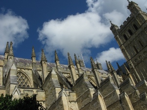 The photo shows a portion of Exeter cathedral, it's light stone contrasting with the bright blue sky