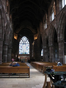 With side arches of alternating dark and light brown stone, and rows of pews all the way up the nave, the church is warm and inviting despite its size.