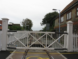 A white gate crosses the road at the Sheringham train station