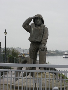 A statue of a lifeguard looking out to sea stands near the bridge in Lowestoft
