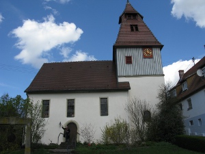 the white church has a brown roof and a one-story bell tower with a clock