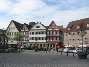 four story buildings surround the town square, some of them timbered.