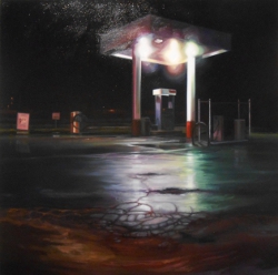 The bright white lights of the small gas station are reflected in the broken shiny asphalt of the wet roadway; loneliness is the mood evoked.