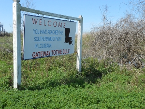 The sign says Welcome at the top, Gateway to the gulf on the bottom, the words in the text and a black outline of the state of Louisiana.