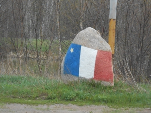 The flag is painted on the side of a large upright stone