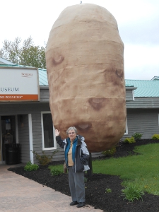 Elsa is standing in front of a giant sculpture of a potato