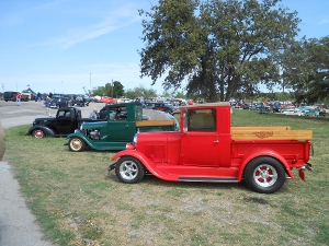 three Ford truck hot rods side by side in black, green, and red