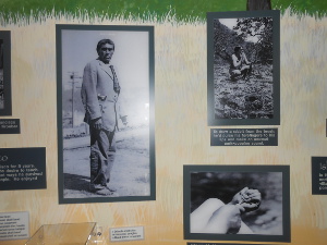 Photographs of Ishi on the museum wall; in the large picture he stands awkwardly in a suit.