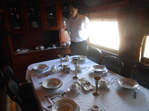 The young tour guide points out the features of the restored dining car.
