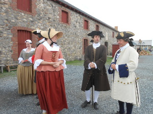 Red, white, royal blue, grey, ecru, colors, along with frilly cuffs adorn the period costumes of the reenactors at Lousbourg.
