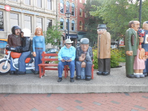 An entire street corner is given over to the sculpture, consisting of motorcycle and rider, bench, and eight of more human statues, with ordinary clothes painted.  Bob sits on the bench next to a man feeding bread to a bird on his knee.