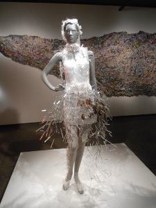 A silvery mannequin wears a silver metallic dress with silver wires fanning out at the skirt in this artistic display