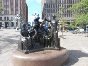 Behind a large bronze art sculpture of muses, Bryan and Madonna poke their heads to join the group