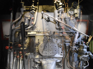 A mass of steel pipes and rivets and rods and plates, all a dull metallic gray, confronts the engineer of a steam locomotive