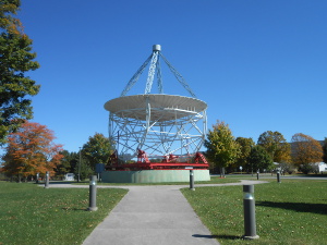 Pointing to the sky, the telescope features a reflecting dish at the bottom and three arms supporting a receptor at the focal point to capture the radio waves