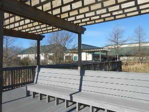 Grey wooden bences on a boardwalk platform outside the Visitor Center