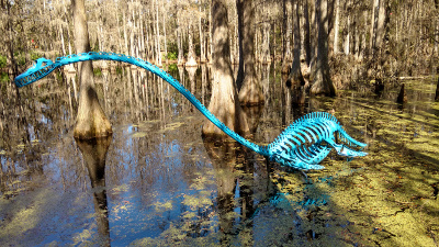 Welded out of parts taken from an auto scrapyard, the long-necked dinosaur sculpture is painted a bright turquoise.