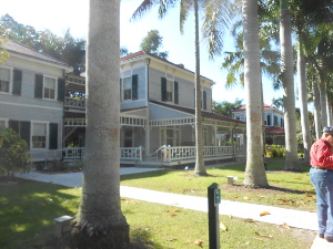 The large white wood home has wide porches all around