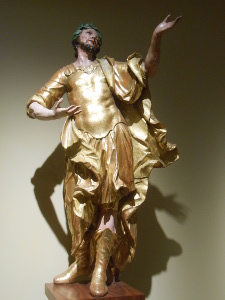 Carved in lime and covered with gilt and warm colors, the man, perhaps a saint, is gesturing and gazing upward.