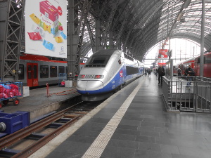 Parked along the platform in the train station, the silver and blue French TGV (trein de grande vitesse) looks streamlined and swift