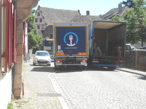 Trucks maneuver with inches to spare in the narrow streets of an Alsace town.