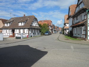 Houses with dormers and white stucco against half-timbered walls line both sides of this street.