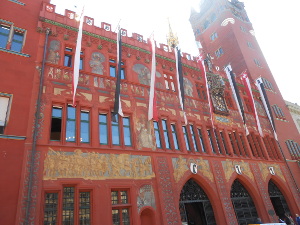 With gold paint trim and dozens of long colored banner, the brick red city hall of Basel is quite memorable