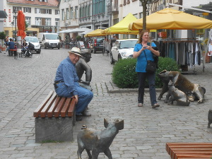 The sculptor has playfully scattered a bronze sow with three piglets and a man watching them all in a public area in Haslach; Bob and Donna are in the midst of the display