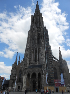 The dark stone Gothic facade focuses the eye on the towering central spire which appears to rise to heaven