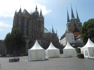 Looking up from the Domplatz, the two churches are silhouetted with sharp Gothic spires against the blue sky.  In the plaza there are white tents being set up for Sunday's charity event.