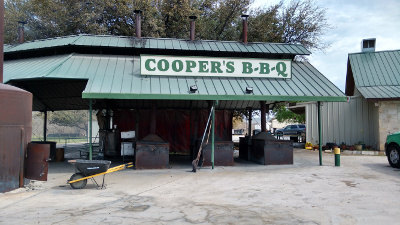 On a green metal roof sits the sign reading 'Cooper's B-B-Q'