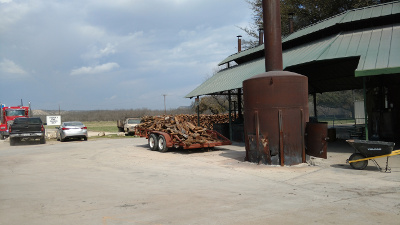 Steel barbecue pits with a trailer full of firewood waiting to be added