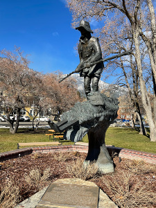 The lifesize bronze shows Thompson carrying a long stick to maneuver through the deep winter snowdrifts