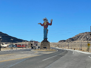 Standing atop a ten-foot pedestal, with his left hand in a wave and his right pointing (once at a casino), Wendover Will has a white cowboy hat, yellow bandana, red shirt, blue jeans, and cowboy boots.