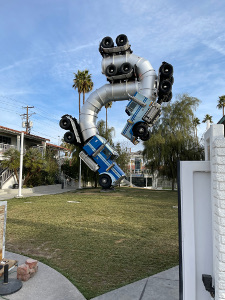 In the side yard of a downtown Las Vegas home is a remarkable sculpture of two semi trucks cut into pieces and welded into a snake like structure.